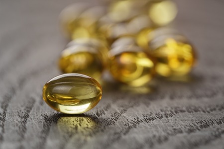 fish oil capsules on wooden tabe health supplement