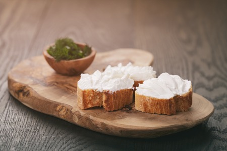 homemade appetizing crostini with soft cheese cream herbs, vintage tonedの写真素材