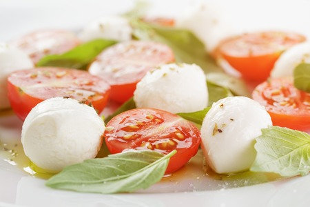 caprese salad with mini mozzarella balls and tomatoes, close up photoの写真素材