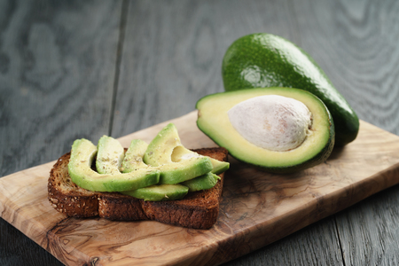 rye toast with sliced avocado and herbs, simple rustic sandwichの写真素材