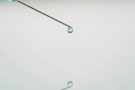 liquid drop on the tip of syringe, shallow focusの写真素材
