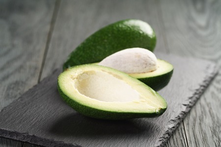 ripe avocados on slate board, shallow focus