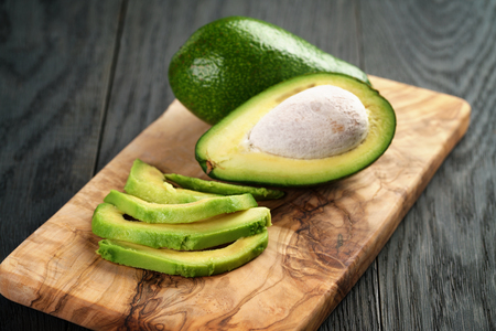 sliced ripe avocados on olive cutting board, shallow focusの写真素材