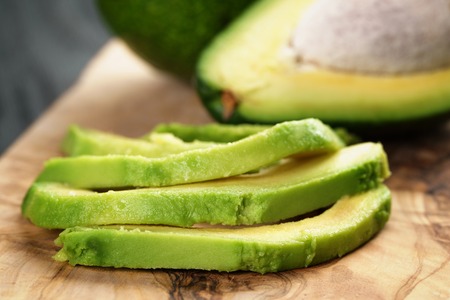 sliced ripe avocados on olive cutting board, shallow focusの写真素材