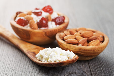 cottage cheese with preserved strawberry in wood bowl on oak table, selective focusの写真素材