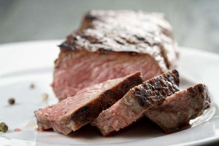 sliced beef steak on white plate close up, shallow focusの写真素材