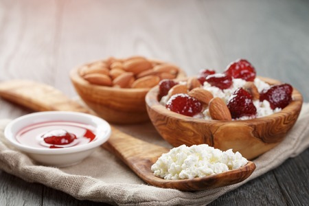cottage cheese with preserved strawberry in wood bowl on oak table, selective focusの写真素材