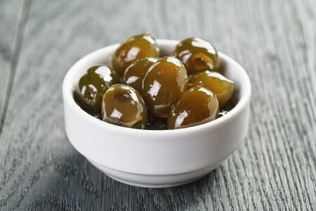 sweet green olives in syrup in bowl, shallow focusの写真素材