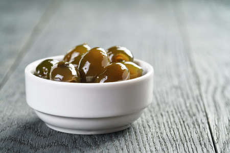 sweet green olives in syrup in bowl, shallow focusの写真素材