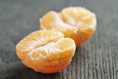 ripe tangerine peeled on wood table, shallow focusの写真素材
