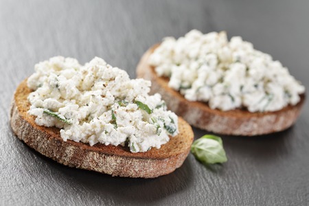 two rye sandwiches or bruschettarye open sandwich with cream cheese and herbs on slate boardの写真素材