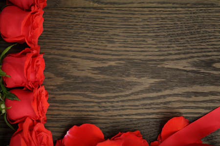 red roses in a row on wood table, directly aboveの写真素材