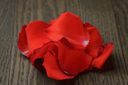 red rose petals on wood table, close upの写真素材