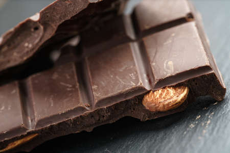 homemade chocolate with almond nuts on slate board, shallow focus
