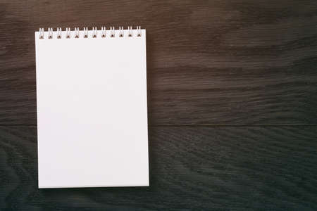 simple blank notepad on rustic wood table, vintage toned