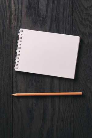 simple blank notepad on rustic wood table, vintage toned