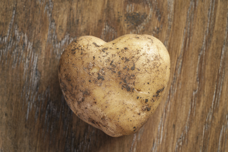 heart shaped potato on oak table, organic foodの写真素材