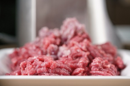 freshly minced beef with purple onion on kitchen table, shallow focus