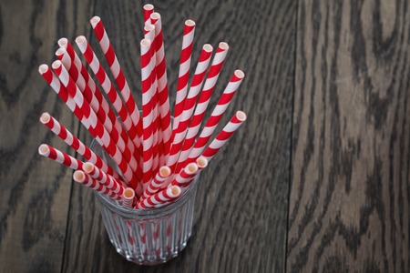 vintage paper straws in glass on wood table, rustic styleの写真素材