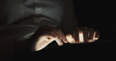 young female teen using tablet pc in the dark environment very shallow focus, 4k photo