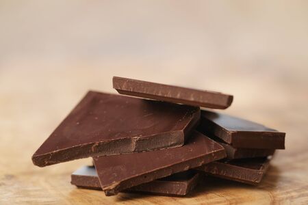 stacked pieces of chocolate bar on wooden table, shallow focusの写真素材