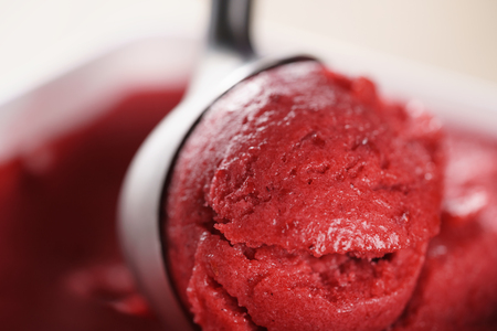closeup photo of raspberry sorbet ball with scoop, shallow focusの写真素材