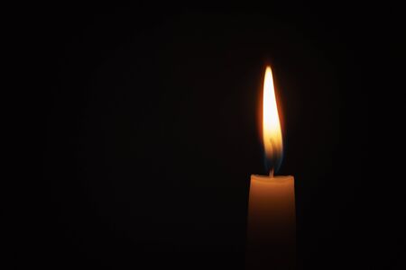 tall candle blown in the dark environment, shallow focusの写真素材