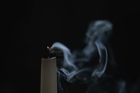 tall candle with smoke trail in the dark environment, shallow focusの写真素材