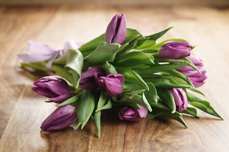 bouquet of purple tulips on wood table, shallow focusの写真素材