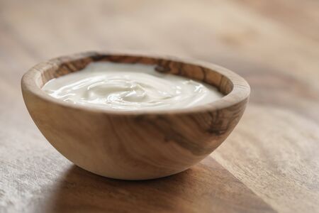 homemade organic yogurt in wooden bowl on table, close upの写真素材