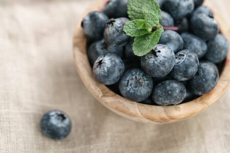 fresh blueberries in bowl on wood table with sack cloth, organic natural food