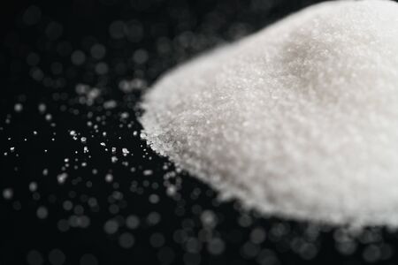 white sugar heap on black background closeup photo, shallow focusの写真素材
