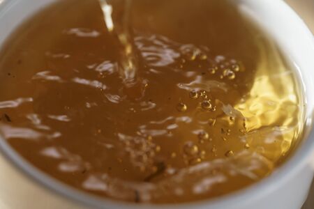 macro photo of pouring puerh tea in cup, shallow focusの写真素材