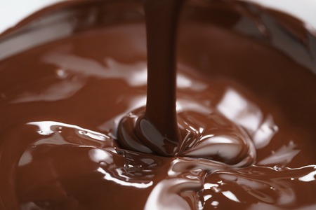 macro photo of premium dark chocolate pour in bowl, shallow focusの写真素材