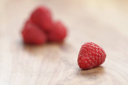 fresh ripe garder raspberries on wood table, closeup photo