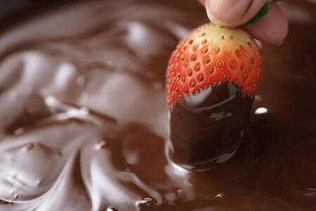 dipping strawberry into dark premium chocolate, with copy spaceの写真素材