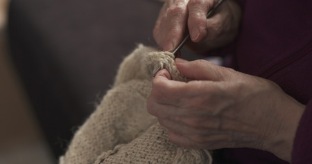 closeup grandmother hands knitting sweater, 4k photo