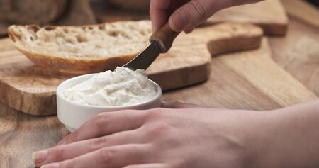 taking ricotta cheese to spread on bread, 4k photoの写真素材