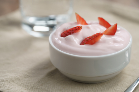 organic strawberry yogurt in white bowl on wood table, shallow focusの写真素材
