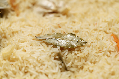 pilaf covered by rice with bay leaves preparing, closeup photoの写真素材