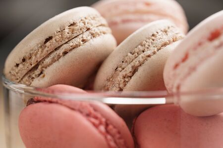 macarons with strawberry, rose and caramel flavour in glass bowl, shallow focusの写真素材