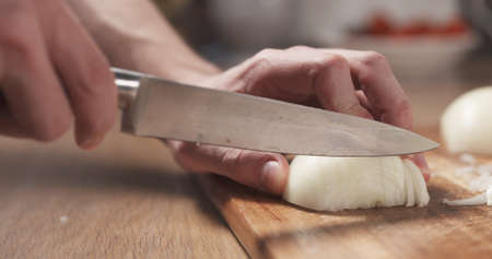 man cutting white onion with knife, 4k photoの写真素材