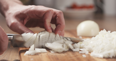 man cutting white onion with knife, 4k photoの写真素材