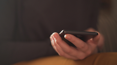 teen girl using smartphone backlit by window light, uhd photo
