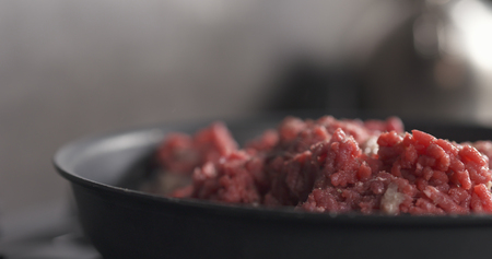 adding pepper to roasting minced beef in a pan, wide photoの写真素材