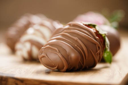 chocolate covered strawberries on wood board, shallow focusの写真素材