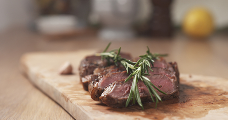 sliced medium rib eye steak with rosemary branch, wide photoの写真素材
