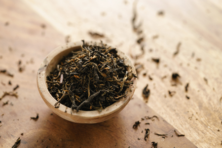 golden orchid tea in small bowl on wood tableの写真素材