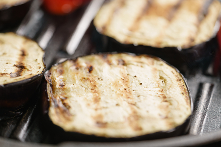 cooking eggplant and pepper on grill panの写真素材