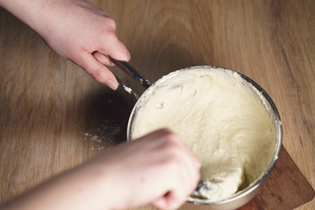 female hands mixing sticky dough, shallow focus